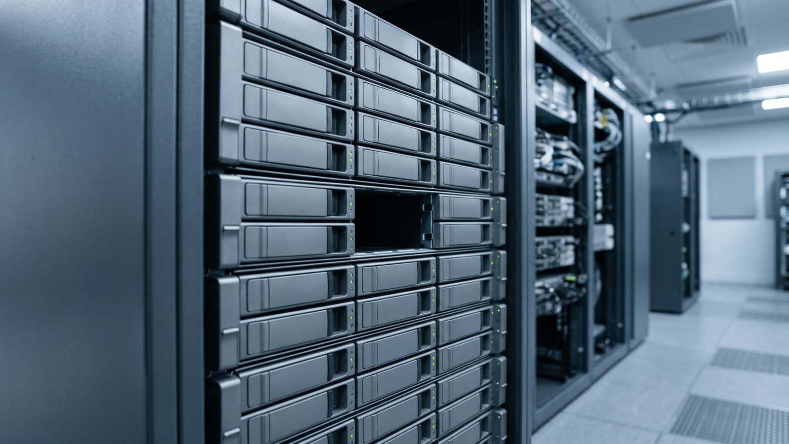 A server rack of unlabelled drive caddies with one slot empty: the question a trade secret theft investigation starts from